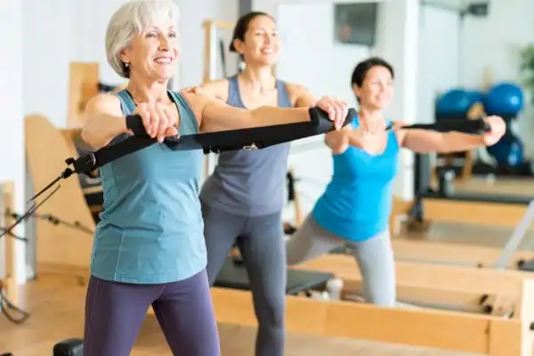 Toning Arms After 60: Empowering Womens Fitness Through Effective Weight Training 2 older woman doing weight training Newmarket and resistance in the gym to tone upper arms