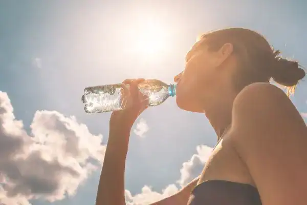 Hydration: The Secret Ingredient for a Toned Stomach and Enhanced Fitness 3 Image of woman drinking water to hydrate Newmarket after run.