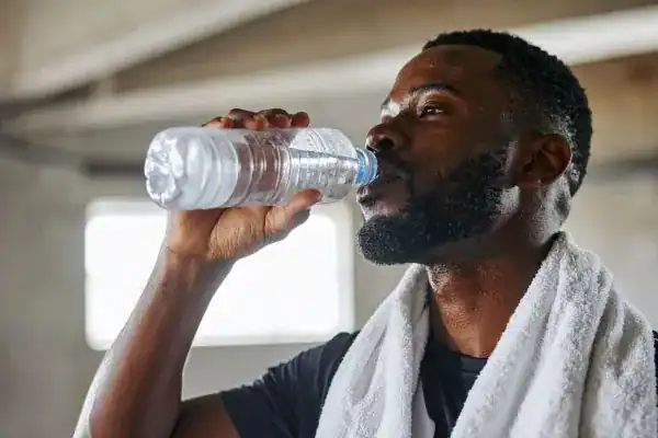 Hydration: The Secret Ingredient for a Toned Stomach and Enhanced Fitness 1 Image of man drinking water to improve hydration Newmarket after work out.